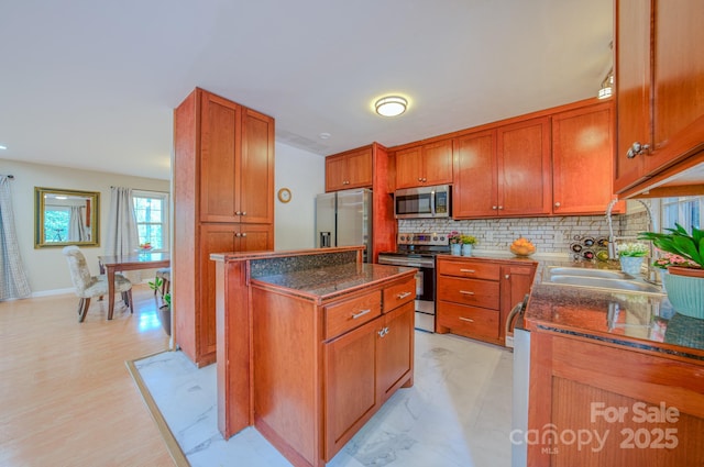 6 Chipmunk Cove Rd, Asheville, NC 28804 - kitchen featuring a center island, stainless steel appliances, tasteful backsplash, and brown cabinets