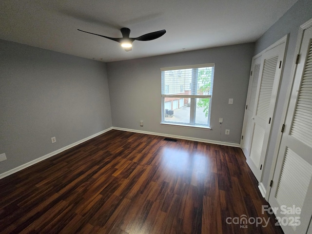 521 Donatello Ave, Charlotte, NC 28205 - unfurnished bedroom with baseboards, dark wood finished floors, and ceiling fan
