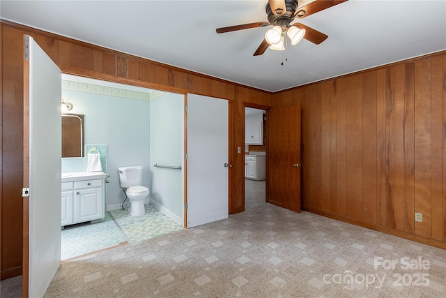 bathroom with toilet, vanity, a ceiling fan, and wood walls