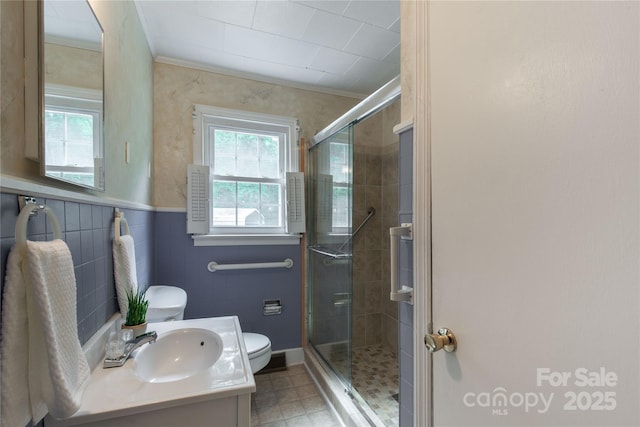 bathroom featuring toilet, a shower stall, ornamental molding, and vanity