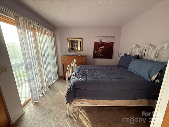 bedroom featuring a textured ceiling, access to outside, and carpet