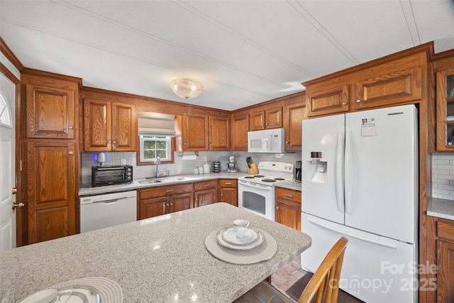 105 Carrie Ln Unit 3, Cherryville, NC 28021 - kitchen with brown cabinets, white appliances, decorative backsplash, and a sink