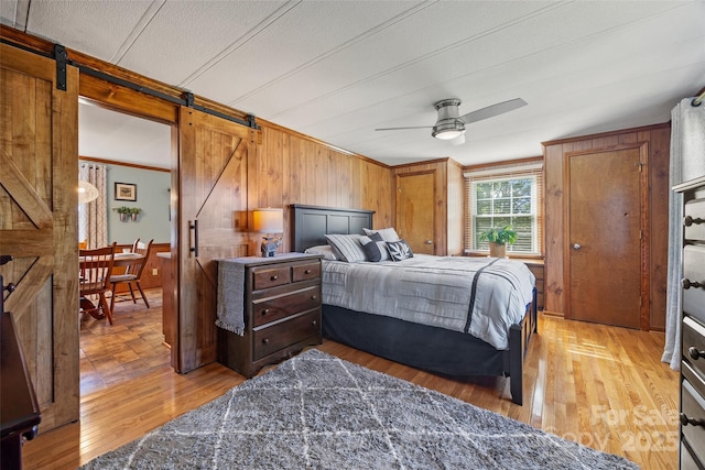 105 Carrie Ln Unit 3, Cherryville, NC 28021 - bedroom with a ceiling fan, crown molding, light wood-type flooring, a barn door, and wooden walls