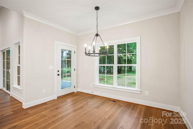 unfurnished dining area with a chandelier, baseboards, visible vents, and a healthy amount of sunlight
