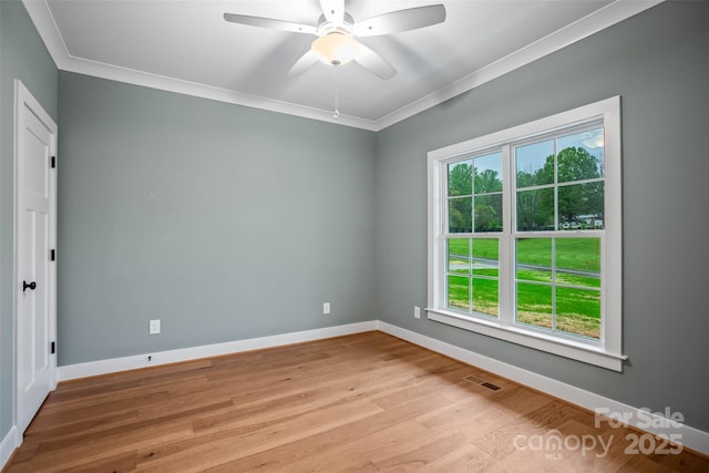 unfurnished room featuring a wealth of natural light, visible vents, and ornamental molding