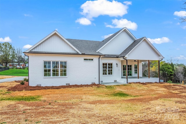 back of property featuring a patio, a ceiling fan, a shingled roof, board and batten siding, and brick siding