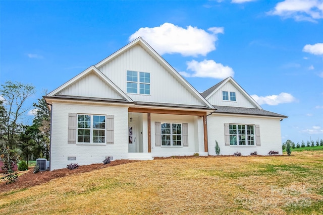 modern farmhouse style home featuring a front lawn, board and batten siding, brick siding, and a porch