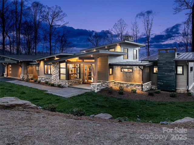 391 High Hickory Trl, Swannanoa, NC 28778 - back of house at dusk with a lawn, french doors, stone siding, an attached garage, and metal roof