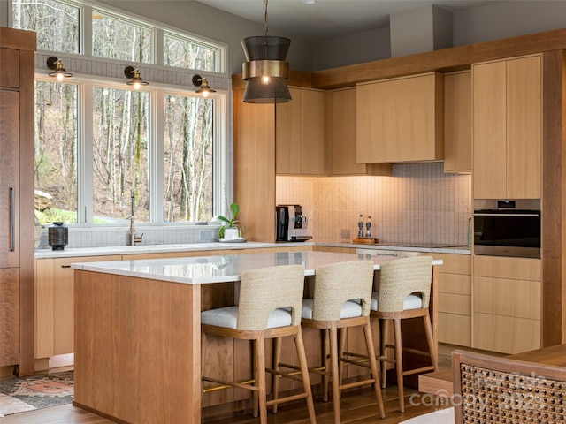 391 High Hickory Trl, Swannanoa, NC 28778 - kitchen with oven, a kitchen island, tasteful backsplash, a kitchen bar, and hanging light fixtures