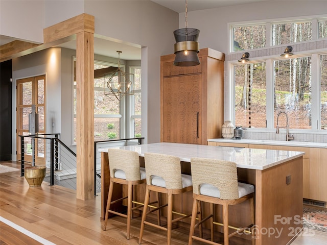 391 High Hickory Trl, Swannanoa, NC 28778 - bar area featuring a sink, light wood-style floors, plenty of natural light, and pendant lighting