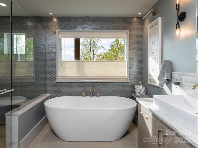 391 High Hickory Trl, Swannanoa, NC 28778 - full bathroom with tile walls, vanity, a soaking tub, and recessed lighting