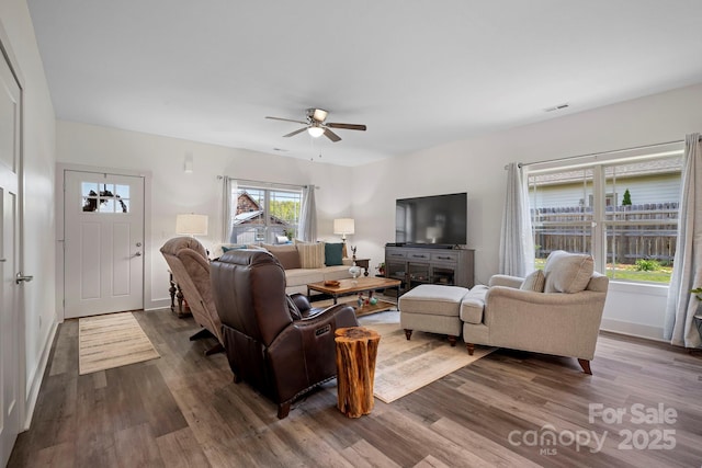 living room with ceiling fan, baseboards, dark wood-style floors, and visible vents