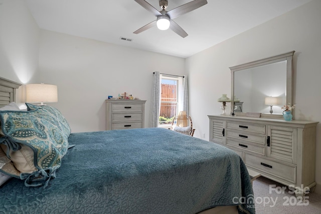 carpeted bedroom with a ceiling fan and visible vents