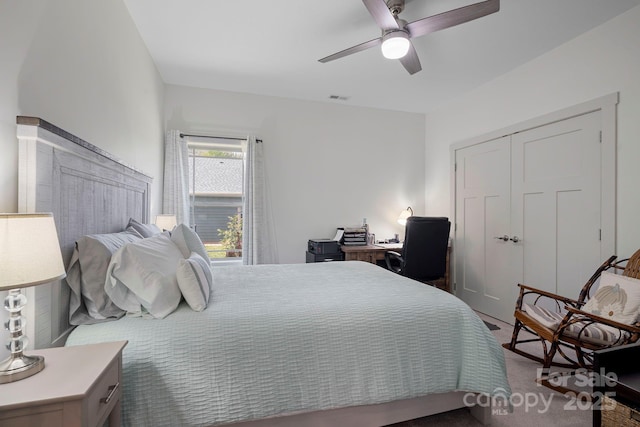 bedroom featuring ceiling fan, a closet, visible vents, and dark carpet