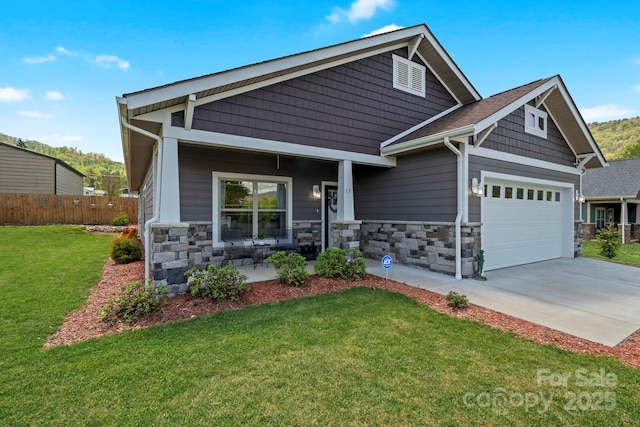 craftsman house featuring fence, a garage, stone siding, and a front yard