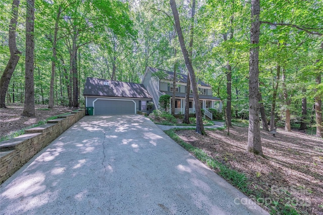 2310 Vestry Pl, Charlotte, NC 28270 - view of front of home featuring a garage, concrete driveway, a porch, and a wooded view