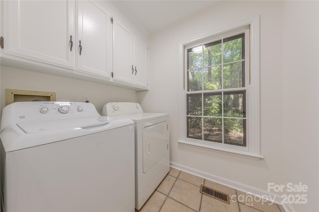 2310 Vestry Pl, Charlotte, NC 28270 - clothes washing area with cabinet space, washing machine and clothes dryer, light tile patterned floors, and baseboards