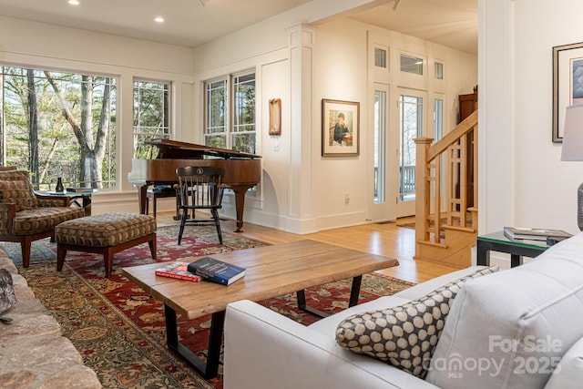 living area with baseboards, stairs, recessed lighting, and wood finished floors