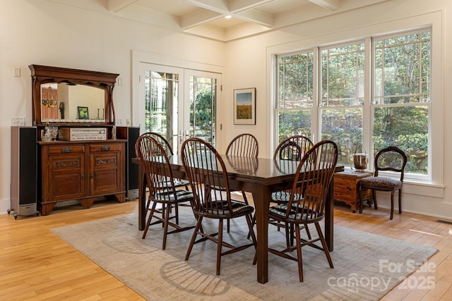 dining room featuring coffered ceiling, light wood-style floors, french doors, and beam ceiling