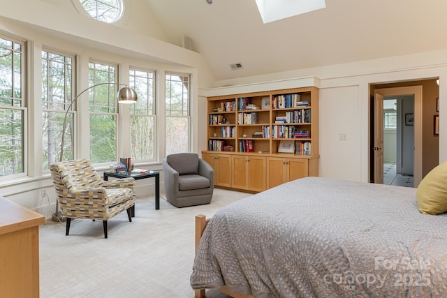 bedroom with light colored carpet, visible vents, a skylight, and high vaulted ceiling
