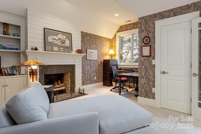 interior space featuring wallpapered walls, visible vents, a lit fireplace, and baseboards