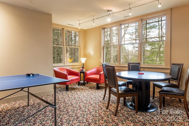 recreation room featuring rail lighting, a healthy amount of sunlight, visible vents, and carpet floors