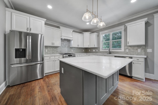 5633 Open Book Ln, Charlotte, NC 28270 - kitchen featuring stainless steel appliances, crown molding, white cabinetry, a kitchen island, and backsplash