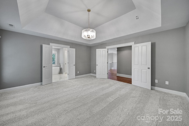 5633 Open Book Ln, Charlotte, NC 28270 - unfurnished bedroom with a raised ceiling, carpet floors, a chandelier, and baseboards