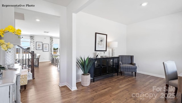 sitting room with wood finished floors, stairway, baseboards, visible vents, and recessed lighting