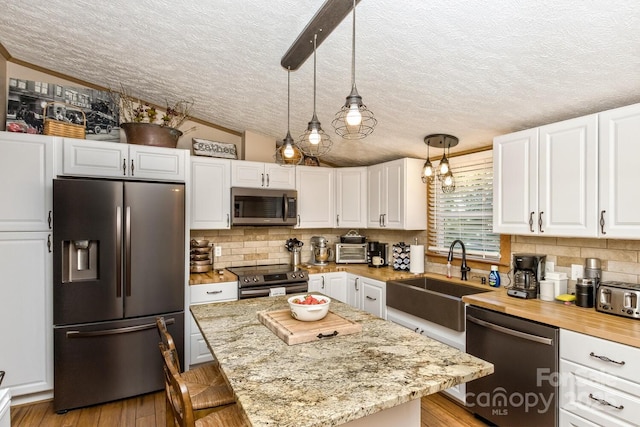 20 Howell Rd, Brevard, NC 28712 - kitchen with stainless steel appliances, a sink, a textured ceiling, white cabinets, and decorative backsplash