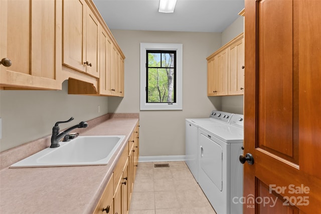 laundry room featuring cabinet space, washer and clothes dryer, baseboards, and light tile patterned floors