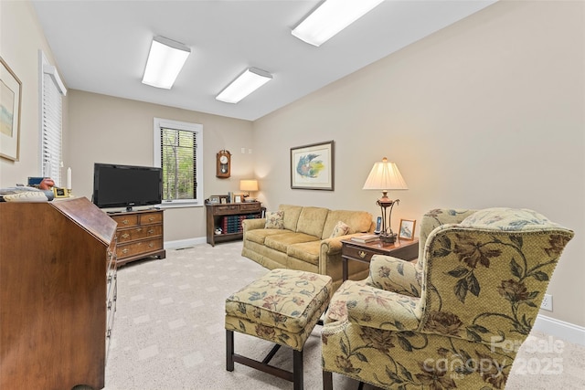 living area featuring light colored carpet and baseboards