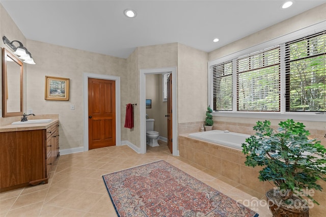 bathroom featuring tile patterned floors, a bath, toilet, vanity, and recessed lighting