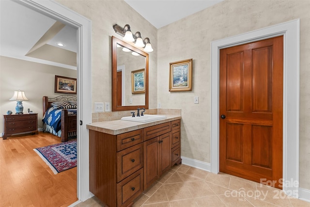bathroom featuring baseboards, vanity, and wood finished floors