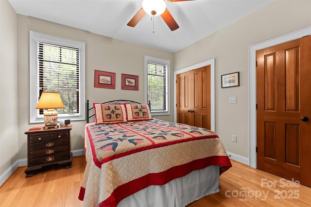 bedroom featuring light wood-style floors, a closet, baseboards, and a ceiling fan