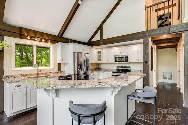 8 Quinn Ct, Asheville, NC 28805 - kitchen with appliances with stainless steel finishes, white cabinetry, dark wood-type flooring, high vaulted ceiling, and glass insert cabinets
