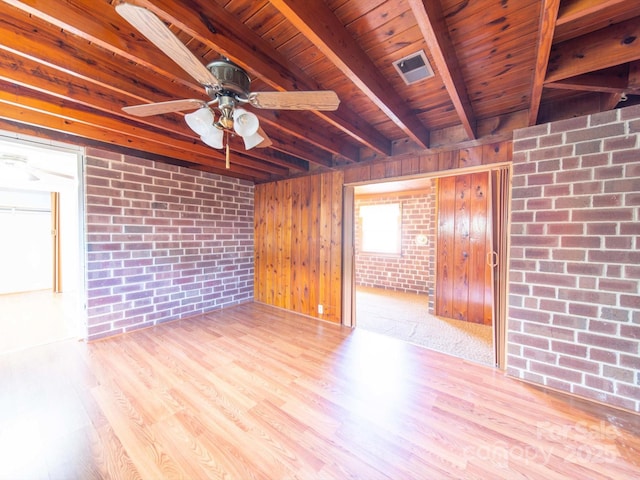 spare room featuring wooden ceiling, beamed ceiling, a ceiling fan, and wood finished floors