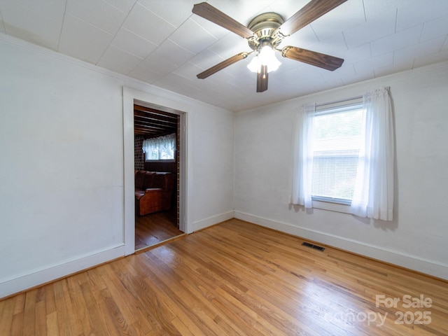empty room with visible vents, baseboards, and ornamental molding
