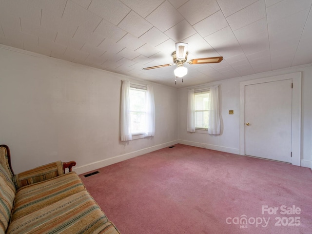 unfurnished room with visible vents, baseboards, a ceiling fan, and light carpet