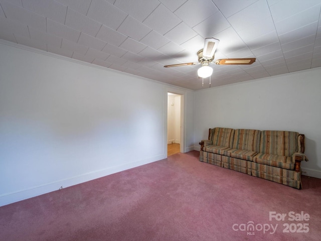 unfurnished living room with carpet flooring, baseboards, and a ceiling fan