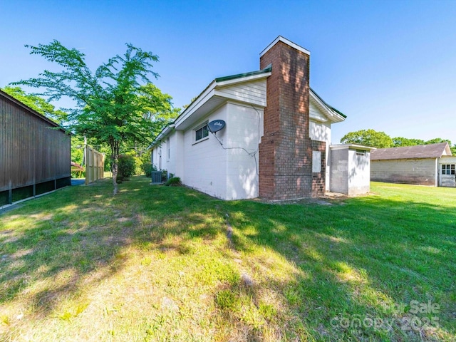exterior space featuring a yard, cooling unit, and a chimney