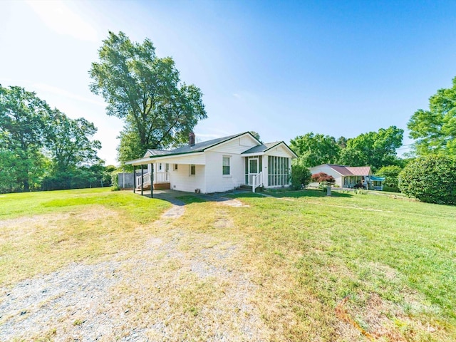 exterior space with a front yard, fence, and a carport