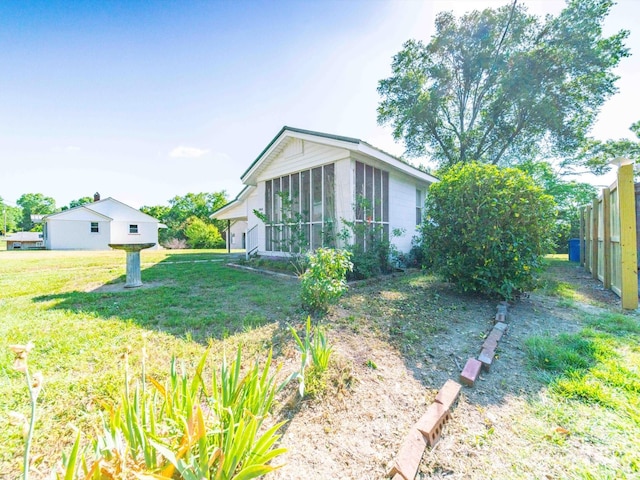 exterior space with a sunroom, fence, and a front yard