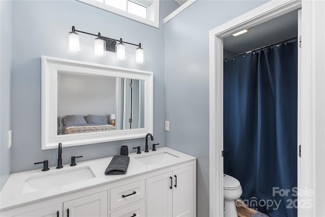bathroom with toilet and double vanity