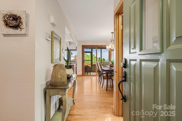 61 Ivy Ridge Rd, Burnsville, NC 28714 - hallway featuring light wood-type flooring and a chandelier