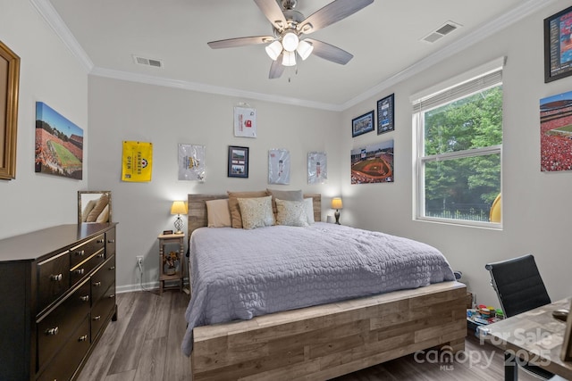 bedroom featuring crown molding, wood finished floors, baseboards, and a ceiling fan
