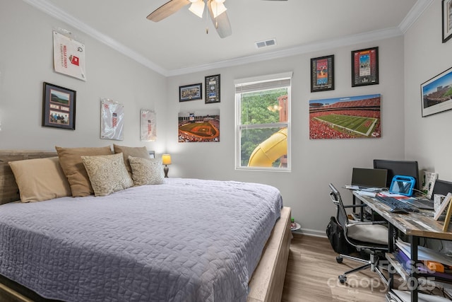 bedroom featuring wood finished floors, ornamental molding, baseboards, a desk, and ceiling fan