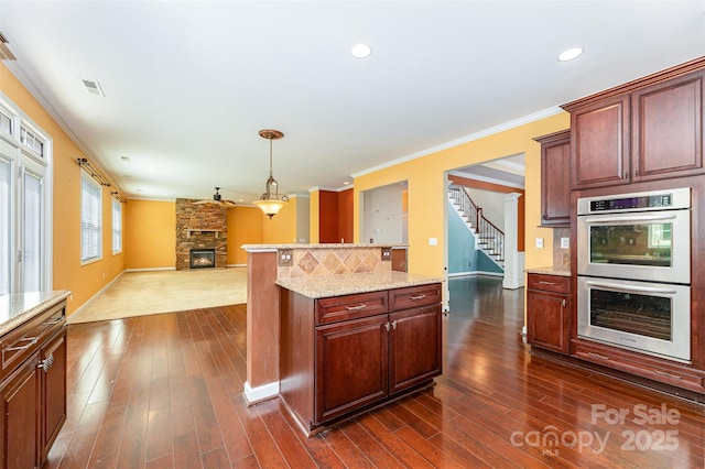 4504 Rockland Ct, High Point, NC 27265 - kitchen with stainless steel double oven, ornamental molding, baseboards, a stone fireplace, and open floor plan