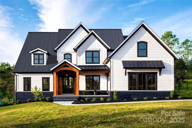 view of front facade featuring a front yard, a standing seam roof, metal roof, and stone siding