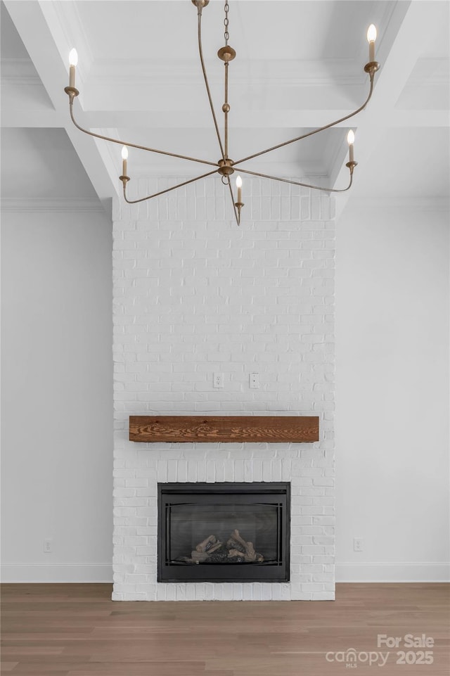 interior details with crown molding, wood finished floors, and a brick fireplace
